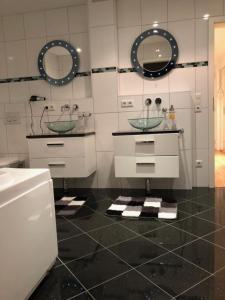 ein Badezimmer mit zwei Waschbecken und zwei Spiegeln in der Unterkunft Ferienwohnung Amperblick Fürstenfeldbruck in Fürstenfeldbruck