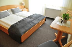 1 dormitorio con cama, escritorio y silla en Gästehaus Hofer, en Gumpoldskirchen