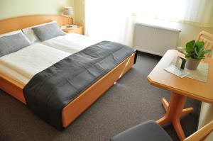 a bedroom with a bed and a desk and a chair at Gästehaus Hofer in Gumpoldskirchen