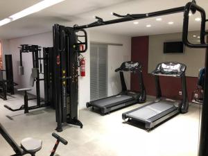 a gym with several tread machines in a room at Verona Tower Hotel in Divinópolis