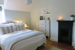 a bedroom with a white bed and a fireplace at 30 Overleigh Road in Chester