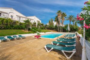 頌帕爾克的住宿－Menorca Villa Fenicia，一组躺椅和一个游泳池