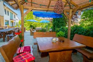 a wooden table and chairs under a wooden pergola at Gasthof Pension Walther in Weißdorf +8 photos