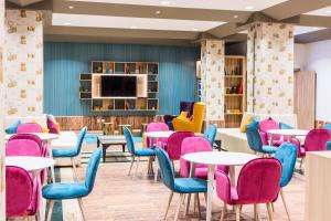 a waiting room with tables and colourful chairs at Hotel Guadalajara & Conference Center Affiliated by Meliá in Guadalajara