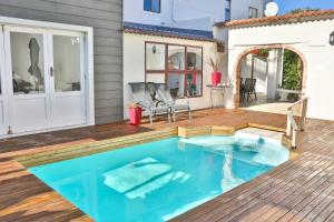 a swimming pool on a deck with a house at Abington Manor Fish Hoek Guesthouse in Fish Hoek
