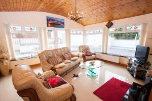 uma sala de estar com sofás, uma mesa e uma televisão em Beezies Self Catering Cottages em Grange