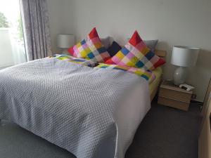 ein Schlafzimmer mit einem Bett mit bunten Kissen in der Unterkunft Studio mit schöner Aussicht in Bad Rothenfelde