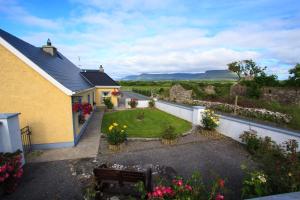 a view of a house with a garden with flowers at Beezies Self Catering Cottages in Grange