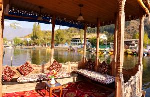 eine Veranda mit Sofas auf einem Boot auf dem Wasser in der Unterkunft White House Group Of Houseboats in Srinagar