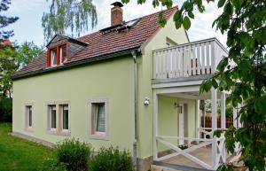 a green and white house with a balcony at Kleines Häuschen - Ferien in Cossebaude in Dresden