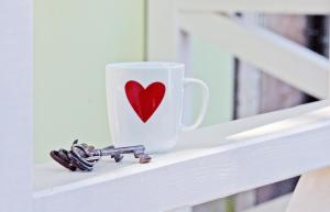 a cup with a heart on it sitting on a shelf at Kleines Häuschen - Ferien in Cossebaude in Dresden