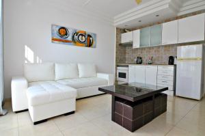een woonkamer met een witte bank en een keuken bij Apartment in Orlando in Adeje