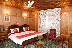 1 dormitorio con 1 cama, 2 sillas y ventana en White House Group Of Houseboats, en Srinagar