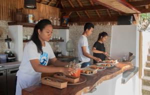 un grupo de personas en una cocina preparando comida en Balcony Ocean View Villas en Kuta Lombok