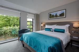 a bedroom with a large bed and a large window at Greenlands Hotel in Henley on Thames