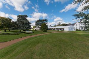 
a large house with a large lawn and trees at Greenlands Hotel in Henley on Thames
