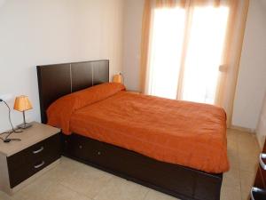 デニアにあるQuiet and Centric Denia Apartmentのベッドルーム1室(オレンジ色の毛布付きのベッド1台付)