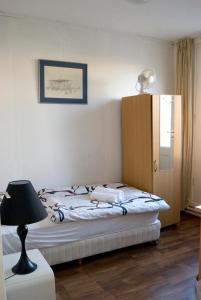 デルフザイルにあるPension Delfzijlのベッドルーム1室(ランプ付)、キャビネットが備わります。
