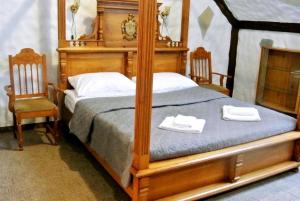 Üksik Rüütel Hotel في Kurna: غرفة نوم بسرير مظلة مع كرسيين