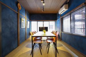 uma sala de jantar com paredes azuis e uma mesa e cadeiras em Copain Kurumi em Kanazawa