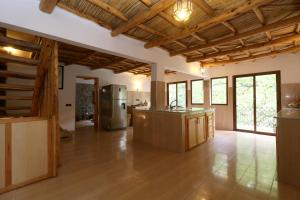 an open kitchen with wooden ceilings and wood floors at Hiba Lodge in Imlil