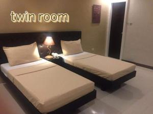 A bed or beds in a room at Urbantel Hotel