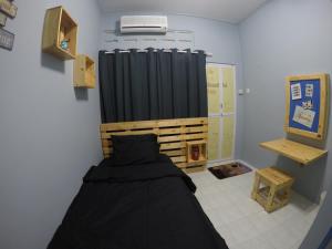 a bedroom with a bed and a black curtain at Little Blue House Kemaman Guesthouse in Cukai