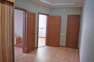 pusty pokój z drewnianymi drzwiami i drewnianą podłogą w obiekcie Apartment Kievskaya 114/2 w mieście Biszkek