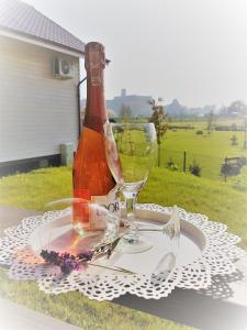 a table with a wine bottle and glasses on it at Magnolia Pokoje Gościnne in Malbork