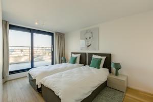 1 dormitorio con 2 camas y ventana grande en The Livorno, en Bruselas