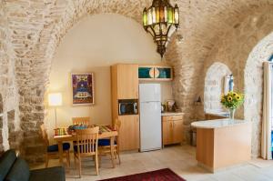 a kitchen and dining room with a refrigerator and a table at Artist Quarter Guesthouse B&B in Safed