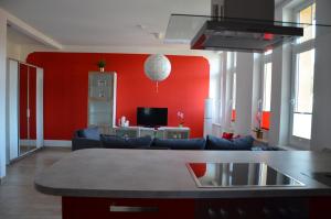 uma sala de estar com um sofá e uma parede vermelha em Ferienwohnung Zenobia em Neu Roggentin
