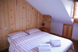 um quarto com uma cama grande e paredes de madeira em Chalet Stella Alpina em Alpe Devero