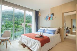 a bedroom with a large bed and a large window at LaRio Hotel Krabi-SHA Extra Plus in Ao Nang Beach