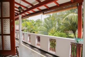 a balcony with a view of a palm tree at Tithira Guest House in Mirissa