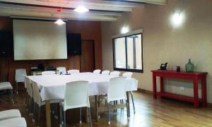 einen Konferenzraum mit einem weißen Tisch und weißen Stühlen in der Unterkunft Tierra Mansa - Posada de Campo & Spa - Piscina Climatizada in Marcos Paz