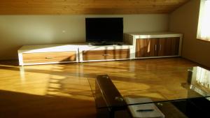 ein Wohnzimmer mit einem Flachbild-TV und einem Entertainment-Center in der Unterkunft Studio Bergblick in Mellau