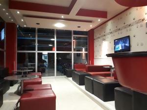 Un restaurante con sillas de cuero rojo y un bar. en Villa Vežić, en Mostar 80 fotos más