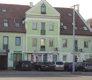a building with cars parked in front of it at Éger Apartman in Eger