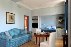 a living room with a blue couch and a table at Dea Suite Roma in Rome
