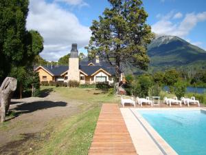 a house with a swimming pool in front of a house at Sendero Lodge in Los Cipreses