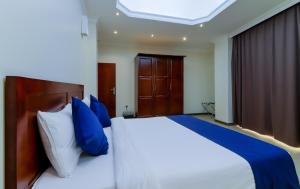 
a bedroom with a large bed and a large window at Tanzanite Executive Suites in Dar es Salaam
