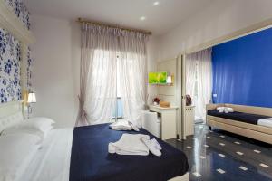 Un dormitorio con una cama con toallas blancas. en Hotel Feldberg, en Riccione