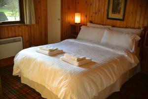 A bed or beds in a room at Loch Monzievaird Chalets