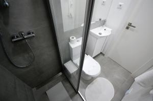 a bathroom with a shower and a toilet and a sink at Vila - Mar - Private outdoor Jacuzzi - wifi & airco - by bedzy in Albufeira +7 photos