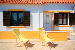 Deux chaises jaunes assises à l'extérieur d'une maison dans l'établissement Vila - Mar - Private outdoor Jacuzzi - wifi & airco - by bedzy, à Albufeira