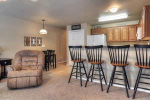 a kitchen with a bar with chairs and a refrigerator at Windrow Retreat in New Braunfels