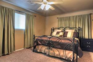 a bedroom with a bed and a ceiling fan at Windrow Retreat in New Braunfels +10 photos