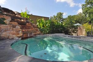 a small swimming pool with a stone wall at Windrow Retreat in New Braunfels
