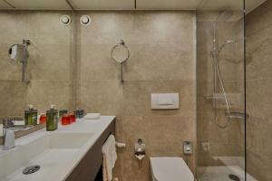 a bathroom with a shower, sink, and mirror at H4 Hotel Residenzschloss Bayreuth in Bayreuth